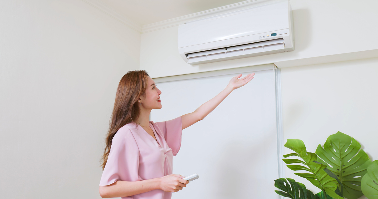 woman turn on air conditioner